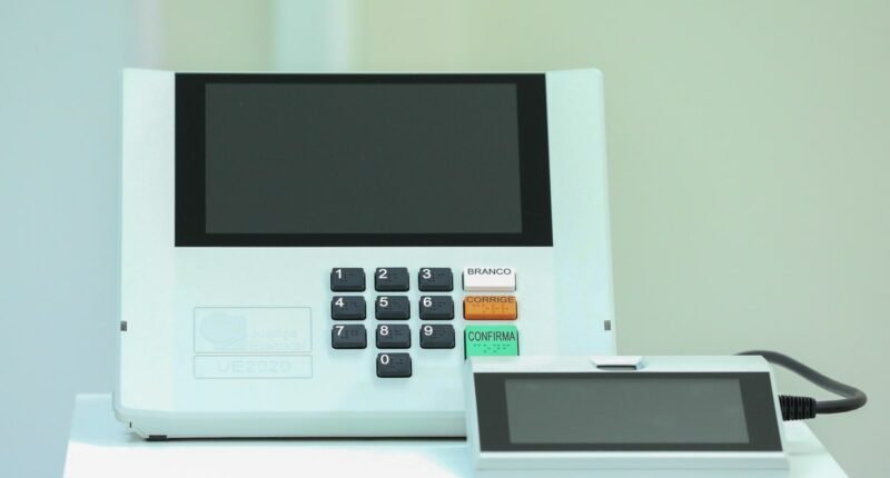 Urna eletrônica brasileira modelo 2020 com teclado numérico e terminal do mesário