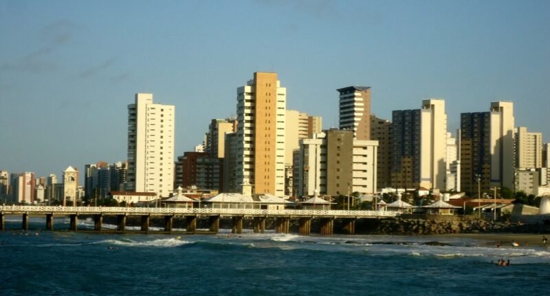 Prédios da orla de Fortaleza vistos do mar, com a Ponte dos Ingleses à frente