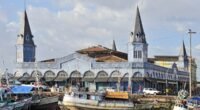 Mercado de Ferro do Ver-o-Peso, com torres pontiagudas, e barcos atracados no cais de Belém