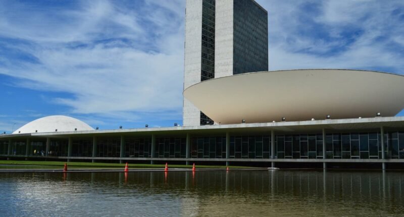 Cúpula do Senado e torres do Congresso Nacional, em Brasília, refletidas no espelho d'água
