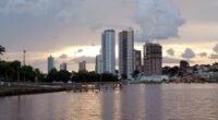 Lago do Parque das Nações Indígenas com prédios de Campo Grande ao fundo, ao entardecer