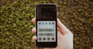 Mão segurando um smartphone com a tela de configurações aberta