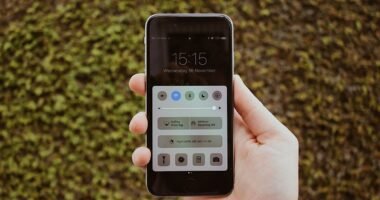 Mão segurando um smartphone com a tela de configurações aberta