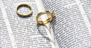 Duas alianças de casamento sobre uma Bíblia aberta
