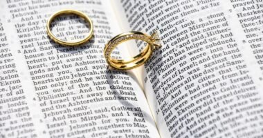 Duas alianças de casamento sobre uma Bíblia aberta